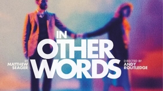 In Other Words show image, two people stand holding hands on a purple cloudy background