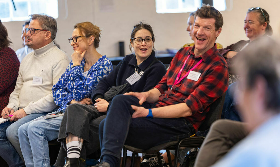 A group of adults sat on chairs laughing and looking engaged, house Network Day 2026