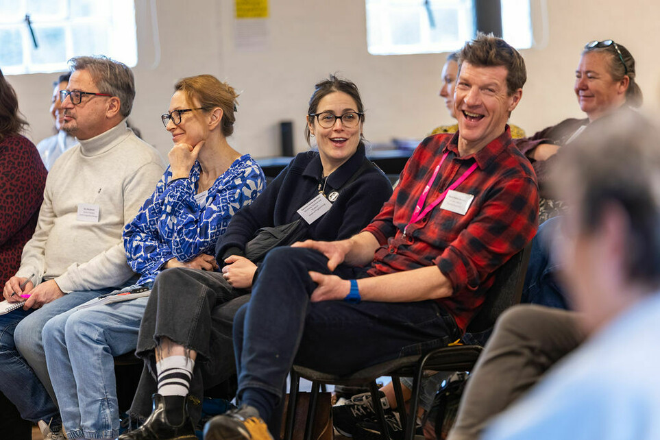 A group of adults sat on chairs laughing and looking engaged, house Network Day 2026