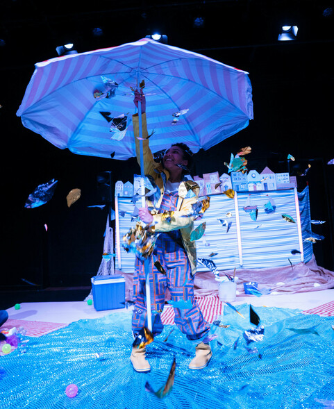 Performer holding up huge beach umbrella