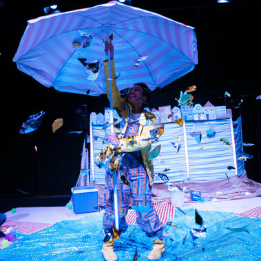 Performer holding up huge beach umbrella
