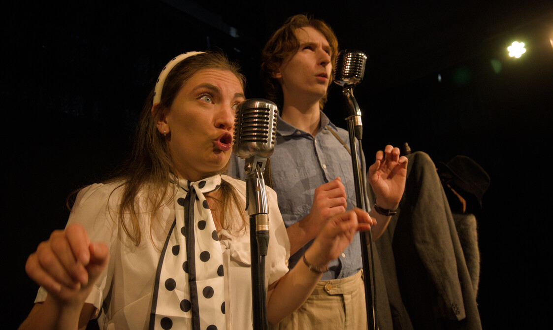 Both performers singing into microphones.