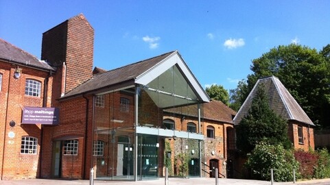 External shot of Farnham Maltings' main entrance. Brick build building with glass entrance.