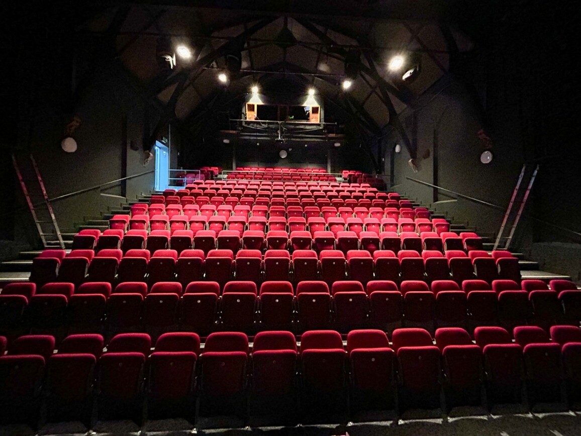 Red theatre seating in a dark auditorium