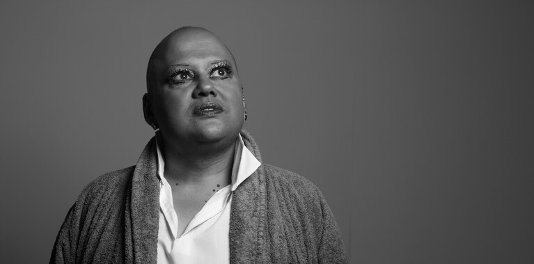 Mono photograph of a man in a dressing gown and shirt staring up to the ceiling