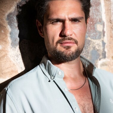 Headshot of Javaad Alipoor, dark hair and facial hair wearing a pale shirt